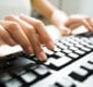 Photo of a person typing on a computer keyboard.