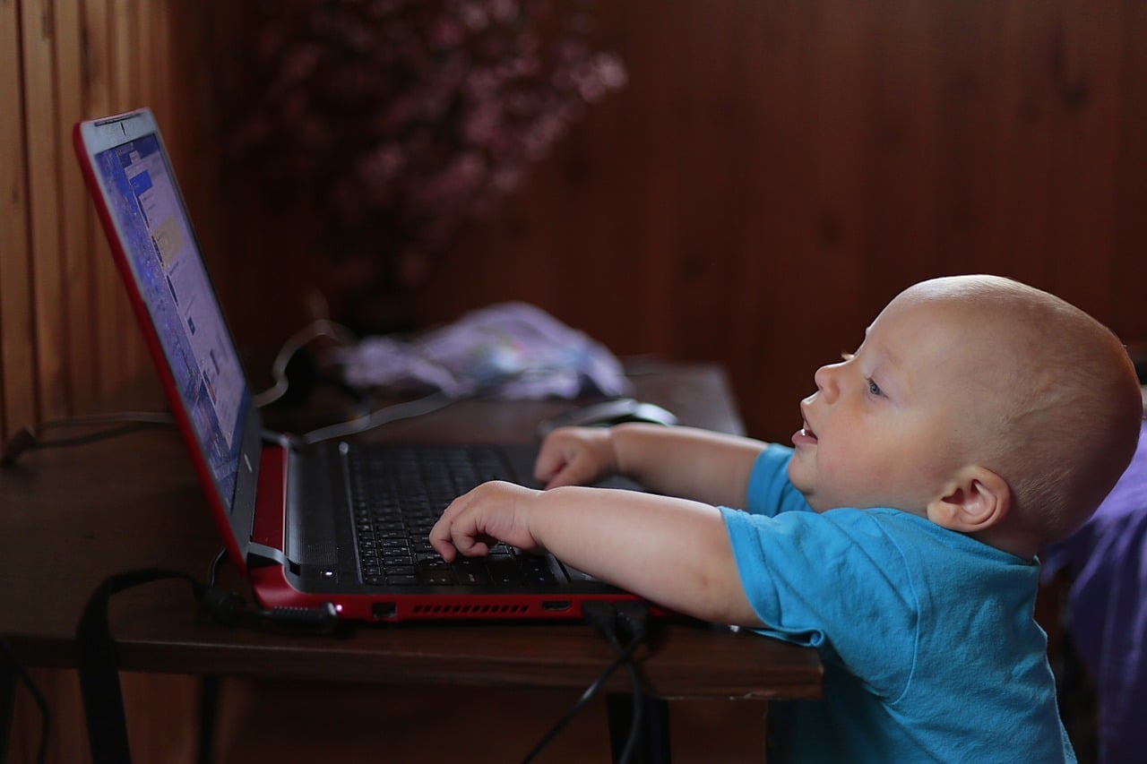 baby using laptop smiling